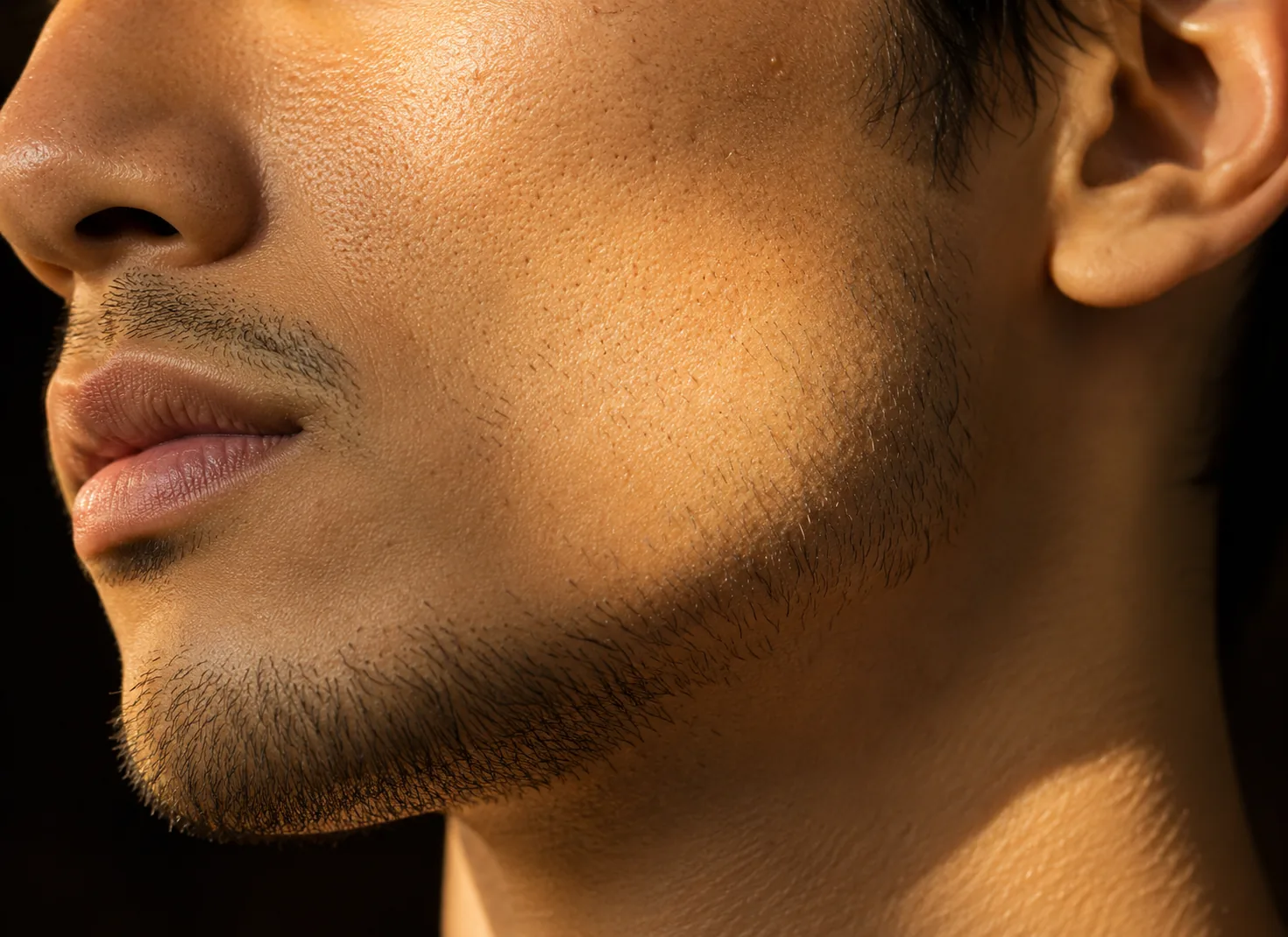 Close view of a man's jaw and cheek showing refined skin texture